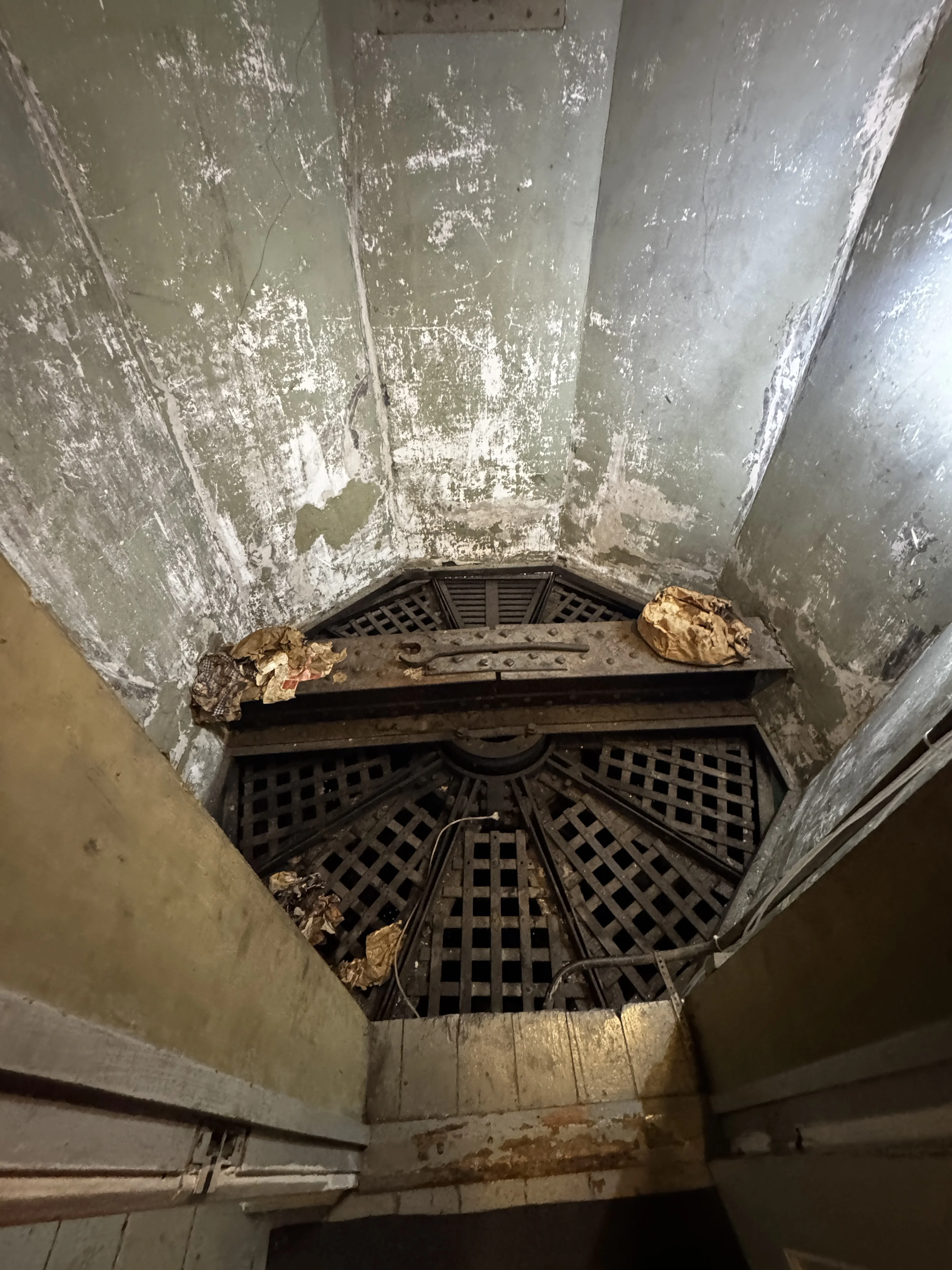 Looking down at the massive circular iron framework and central riveted steel pivot beam supporting the rotating cell drum